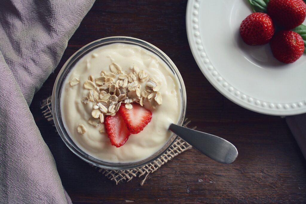 Yogurt with strawberries and oats on it.  